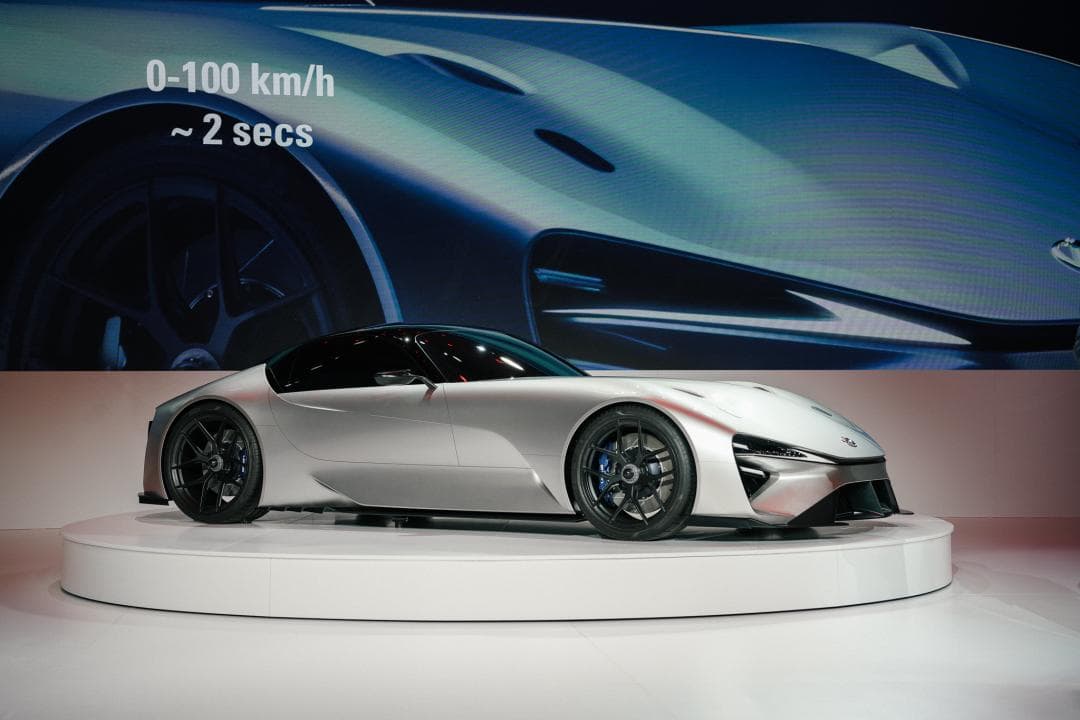 Lexus All-Electric Sport Concept, voiture blanche futuriste exposée sur un podium, avec affichage 0-100 km/h en 2 secondes en arrière-plan