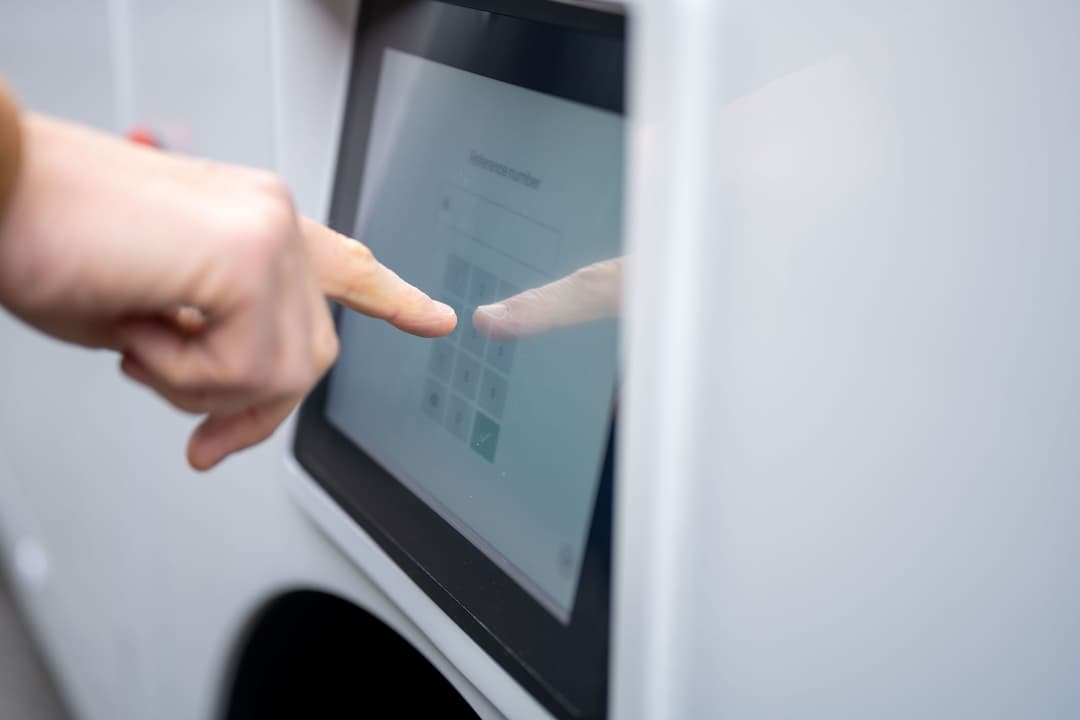 Main pointant vers un écran tactile intégré au véhicule autonome de livraison LOXO