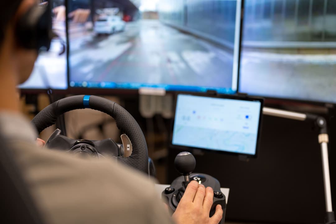 Poste de contrôle du véhicule autonome LOXO avec volant, écrans de surveillance et vue de la circulation urbaine
