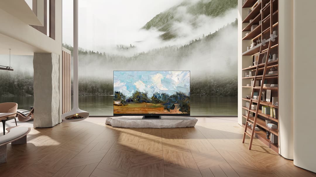 Téléviseur TCL C93 Series affichant un paysage montagneux, posé dans un salon moderne avec grandes baies vitrées