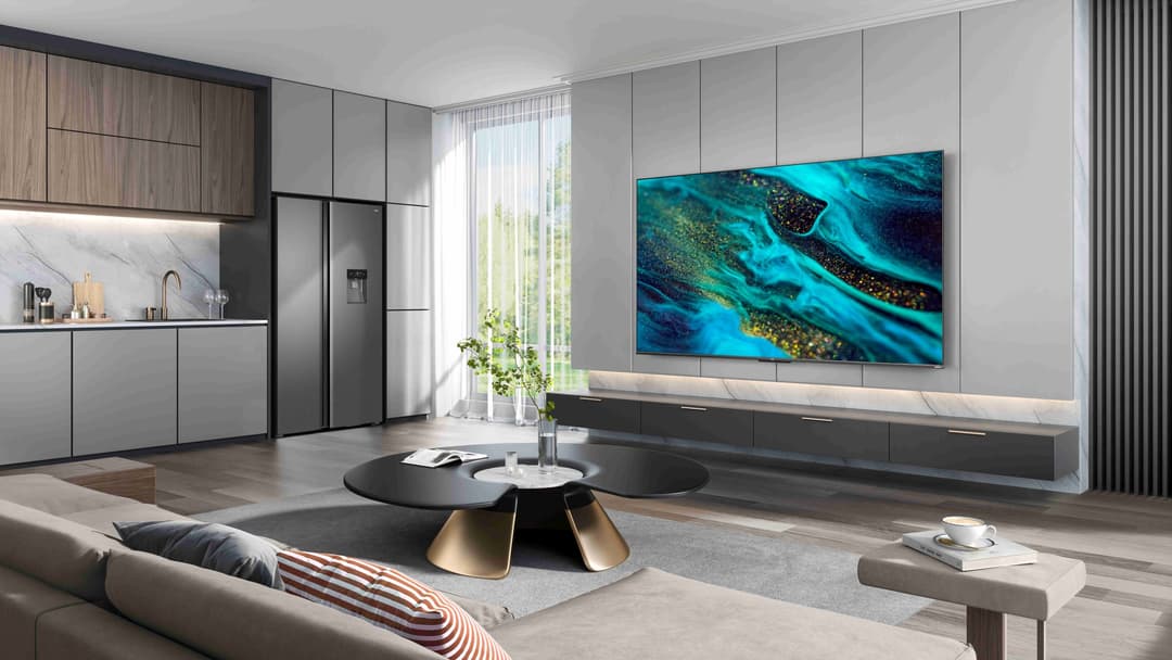 Téléviseur TCL Mini LED affichant une image aérienne de récifs coralliens, fixé au mur d'un salon moderne