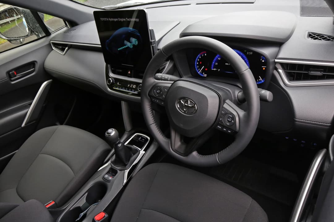 Habitacle du Toyota Corolla Cross H2 Concept avec volant, tableau de bord numérique bleu et écran tactile affichant la technologie hydrogène