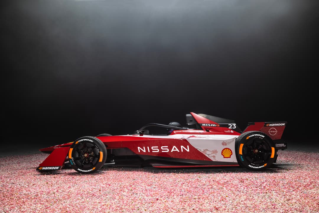 Monoplace Nissan Formula E Gen3 rouge et blanche avec motif fleur de cerisier, numéro 23, sur un sol paillé rose