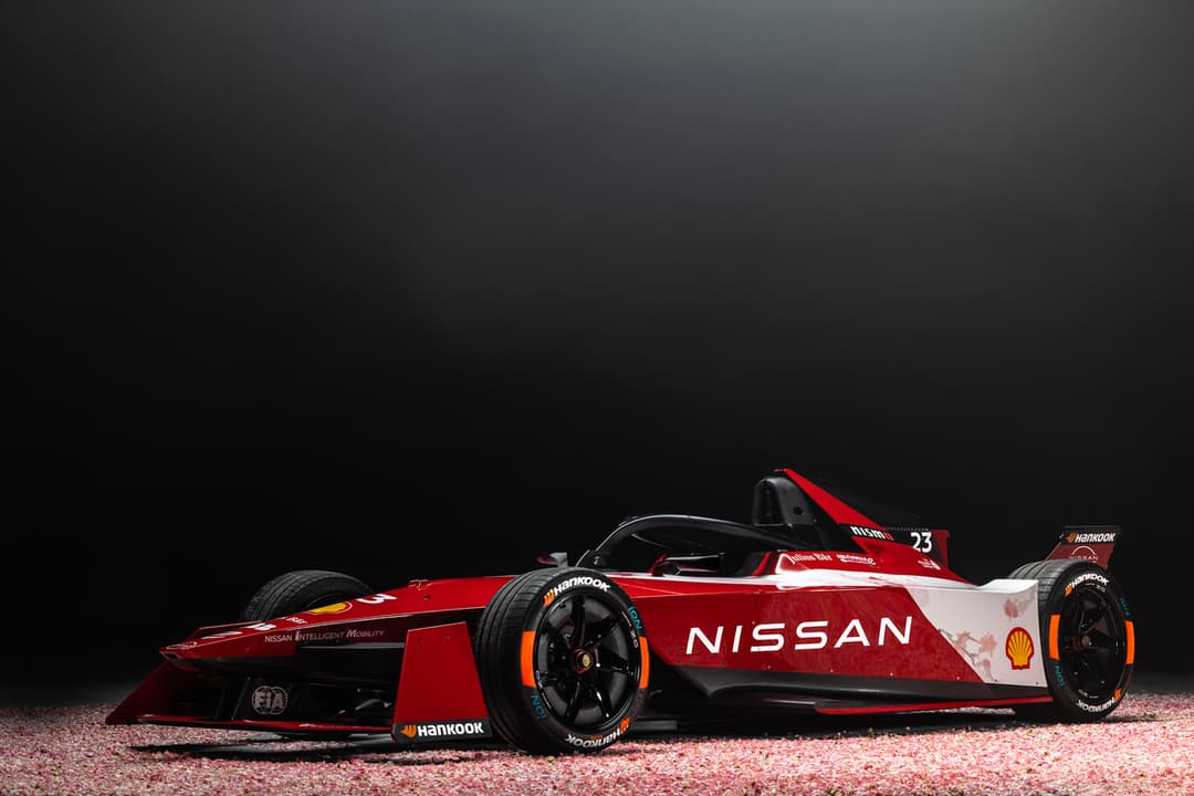 Voiture de course Nissan Formula E Gen3 rouge et blanche avec logo Shell, vue de profil sur fond noir