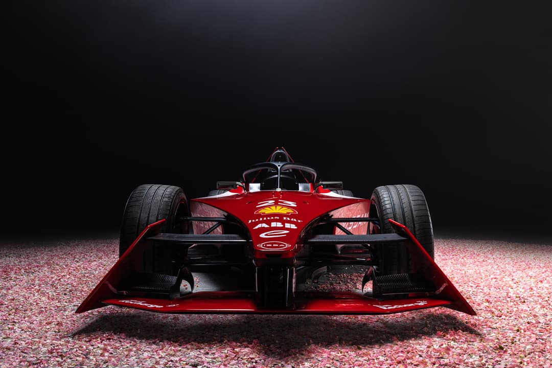 Monoplace Nissan Formula E rouge vif de face, avec livrée spectaculaire aux accents jaunes et noirs, sur fond sombre