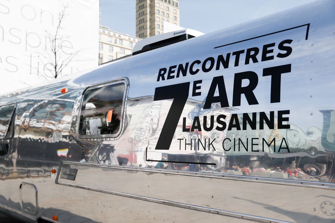 Caravane argentée avec inscription « Rencontres 7 Art Lausanne Think Cinema » stationnée en centre-ville