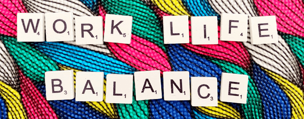 Lettres de Scrabble formant les mots « Work Life Balance » sur un tissu coloré multicolore