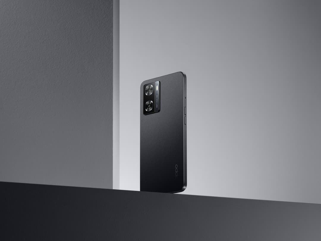 OPPO A57s noir avec module caméra de 50 MP, posé verticalement sur surface grise et blanche
