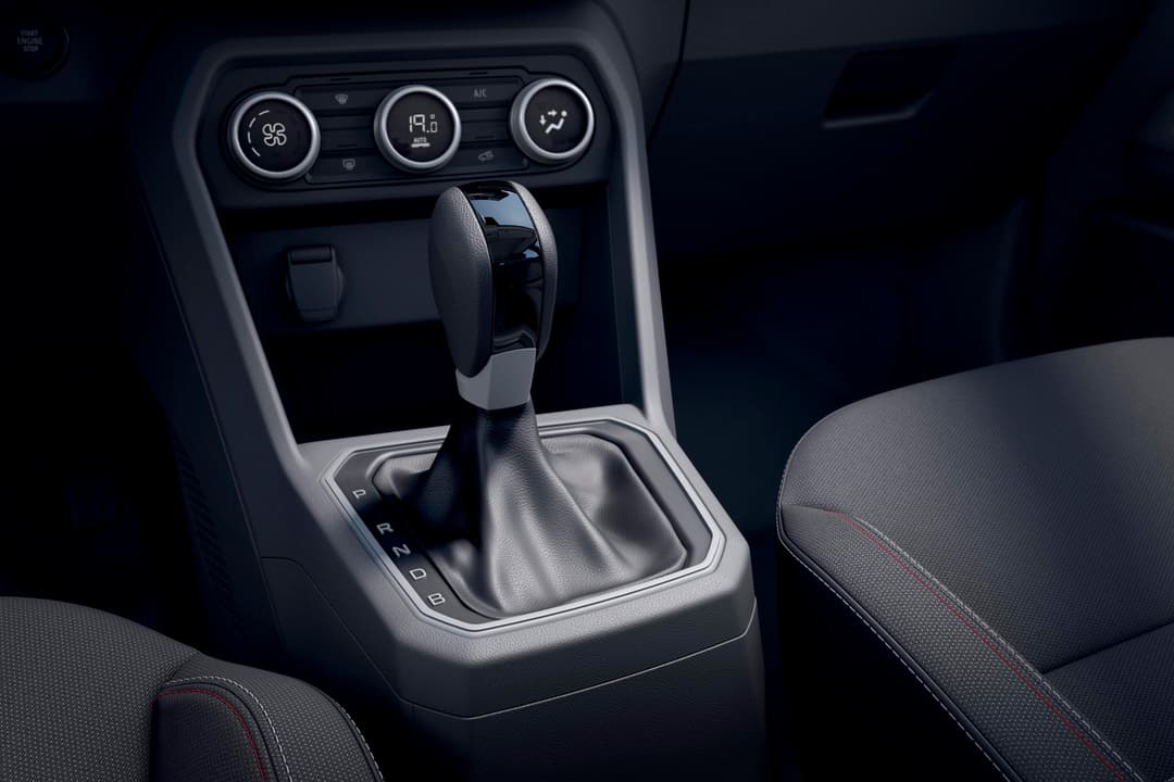 Intérieur du Dacia Jogger Hybrid 140, détail de la console centrale avec levier de vitesses et commandes de climatisation