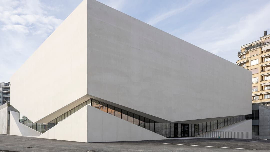 Musée de l'Elysée à Lausanne, bâtiment moderne aux formes géométriques et façade blanche, avec entrée vitrée et bâtiments historiques adjacents