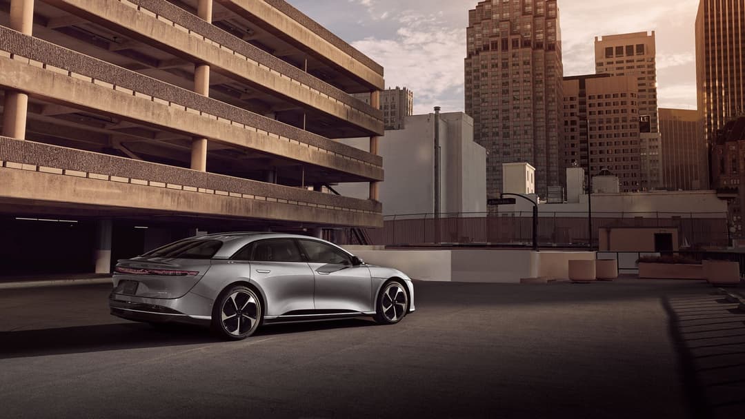 Lucid Motors, berline électrique argentée stationnée sous un parking en béton dans un environnement urbain