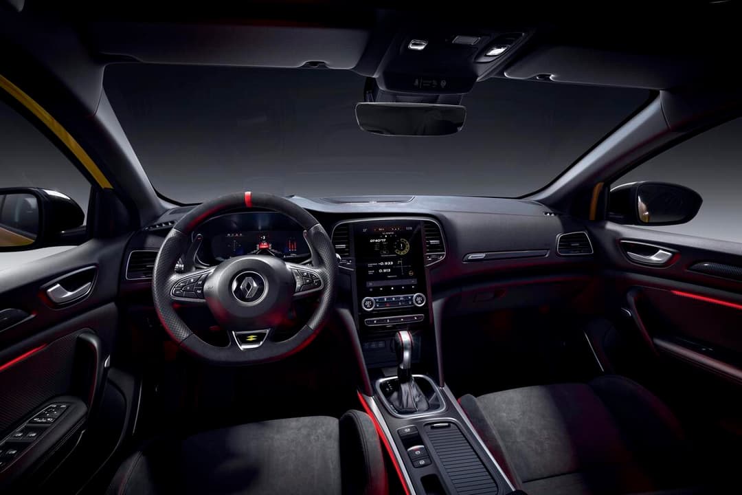 Habitacle de la Renault Megane R.S. Ultime avec volant sportif rouge et noir, écran tactile central, sièges et détails intérieurs aux accents rouges