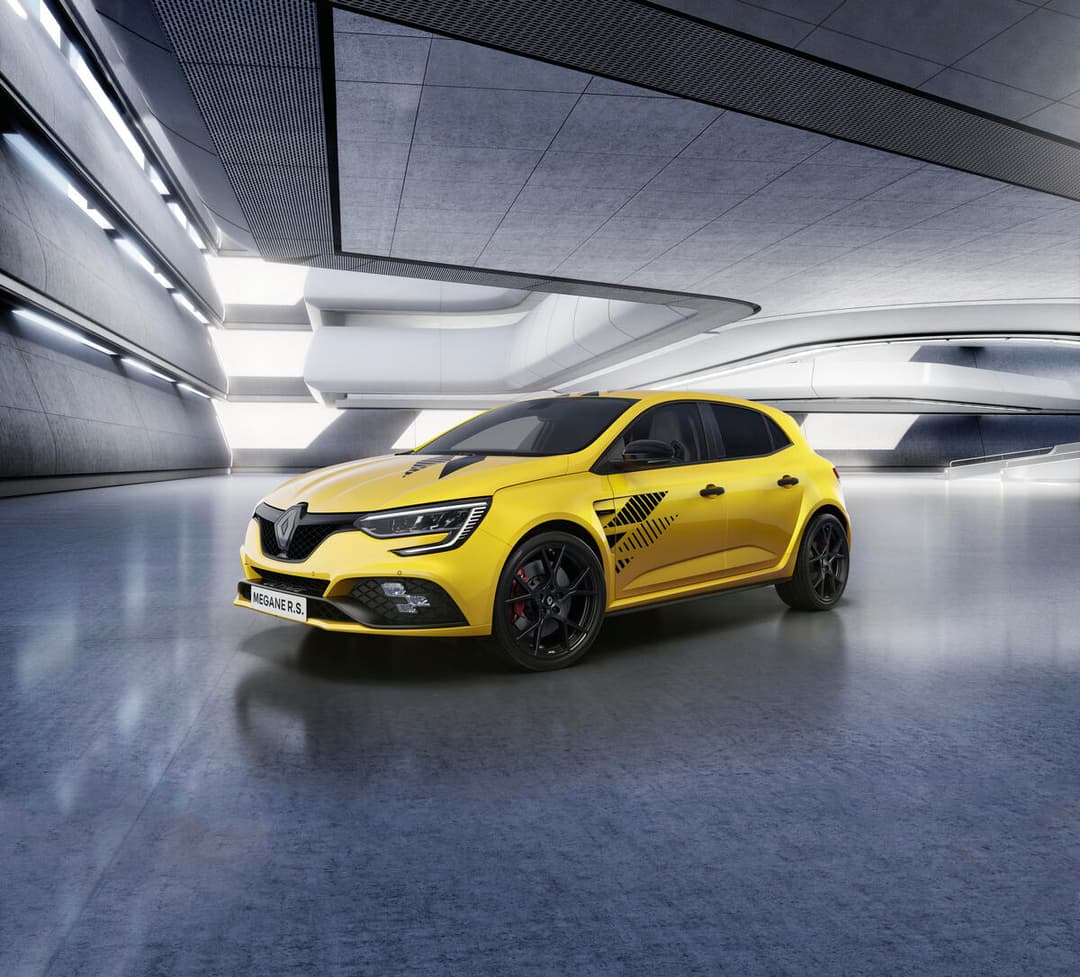 Renault Megane R.S. Ultime jaune vif, jantes noires 19 pouces, freins rouges, dans un parking moderne