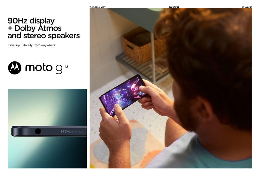 Personne tenant un Motorola moto g13 avec écran affichant du contenu vidéo violet, publicité du téléphone avec écran 90Hz et haut-parleurs Dolby Atmos