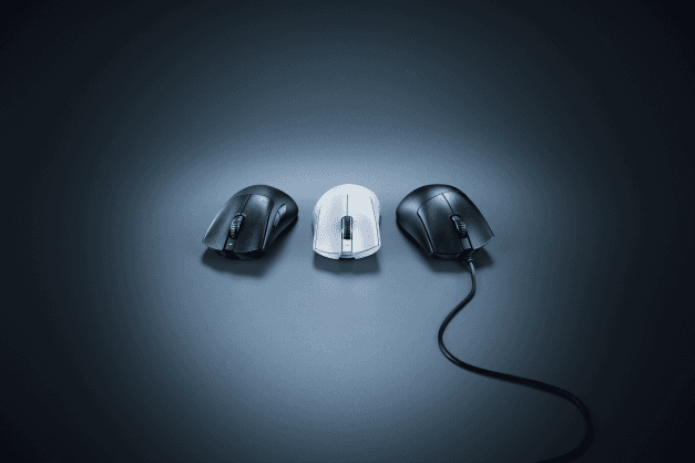 Trois souris Razer DeathAdder V3 alignées, deux noires et une blanche, avec câble Speedflex visible