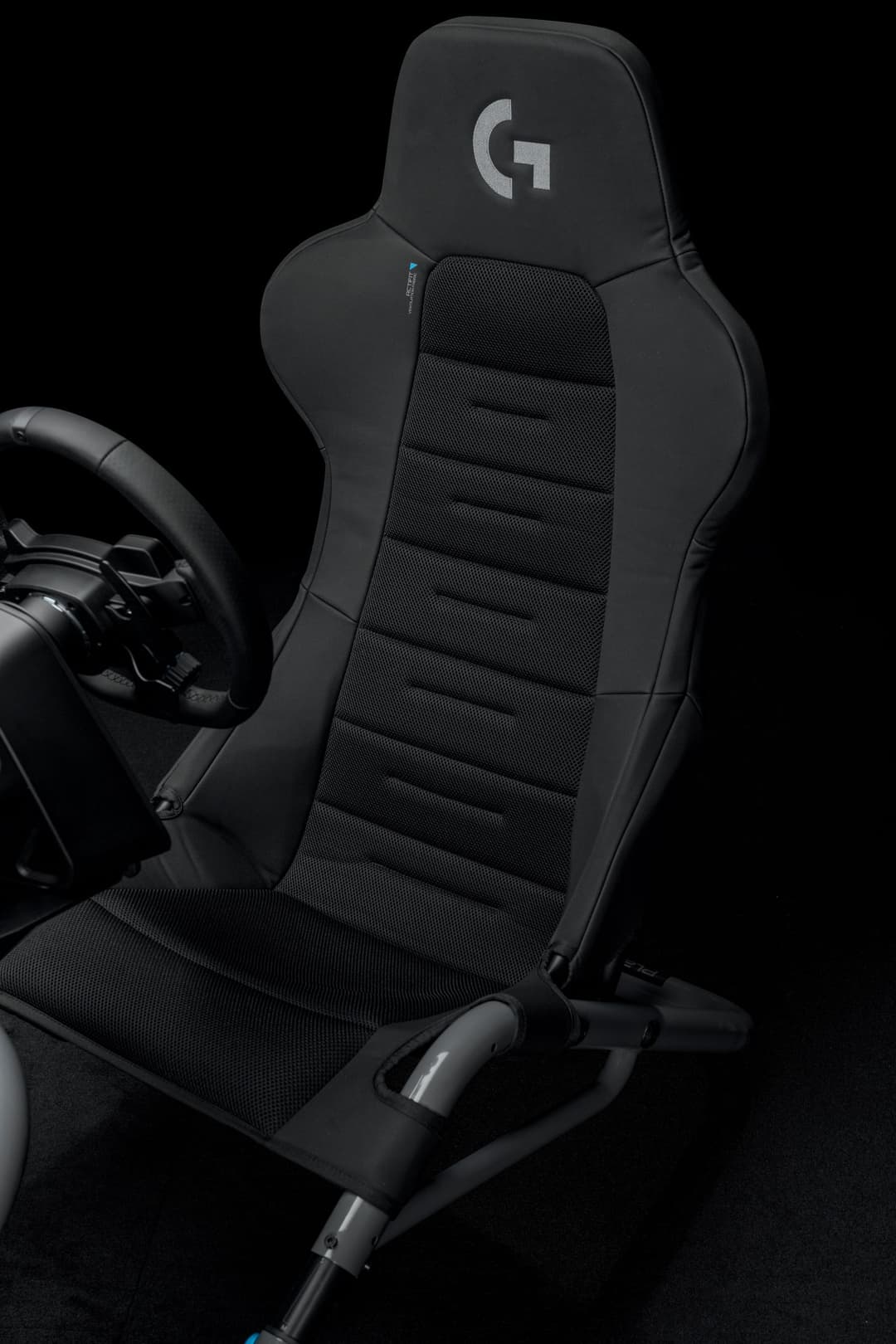 Siège de course Playseat Trophy-Logitech G Edition noir avec logo G, volant de racing visible à gauche