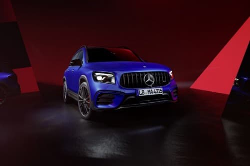 Mercedes-Benz GLB AMG bleu électrique, phares LED allumés, sur fond géométrique rouge et noir