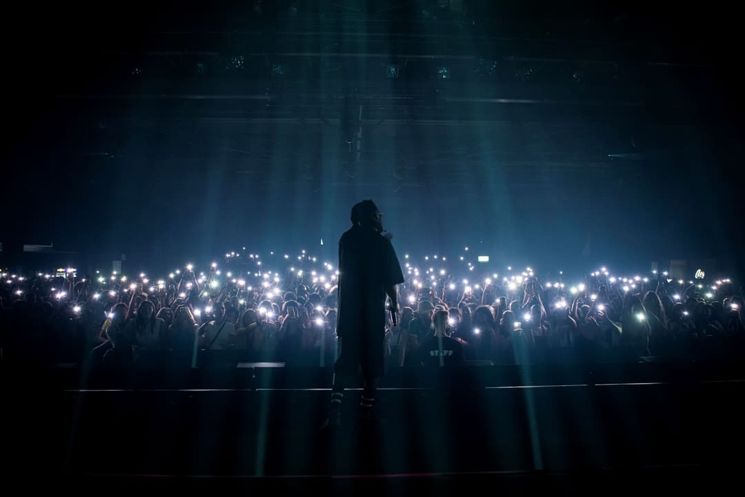 Musicien sur scène face à une foule tenant des téléphones illuminés au Montreux Jazz Festival