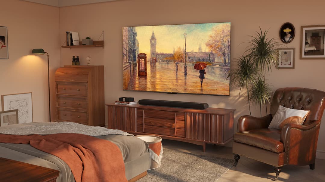 Téléviseur QLED TCL série C64 affichant une scène londonienne avec Big Ben, fixé au mur d'une chambre aux tons chauds