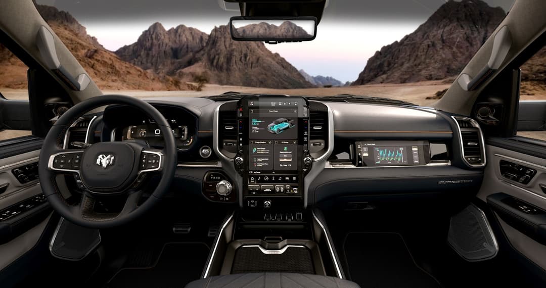 Intérieur du Ram 1500 REV électrique 2025 avec tableau de bord numérique, volant et écran tactile central affichant les données du véhicule