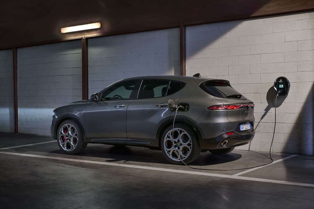 Alfa Romeo Tonale Plug-In Hybrid Q4 gris métallisé en recharge sur une borne, dans un garage souterrain