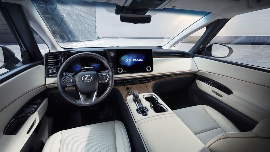 Habitacle du Lexus LM avec volant, écran tactile et sièges en cuir blanc, design luxe épuré