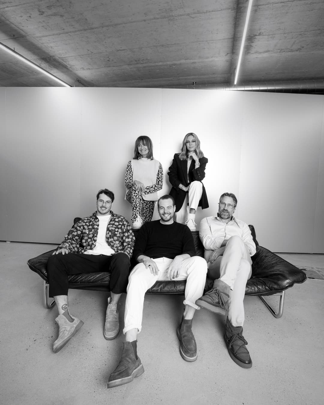 Cinzia Maag et ses fils Danilo et Alessio posent ensemble dans un atelier minimaliste, assis sur un canapé noir