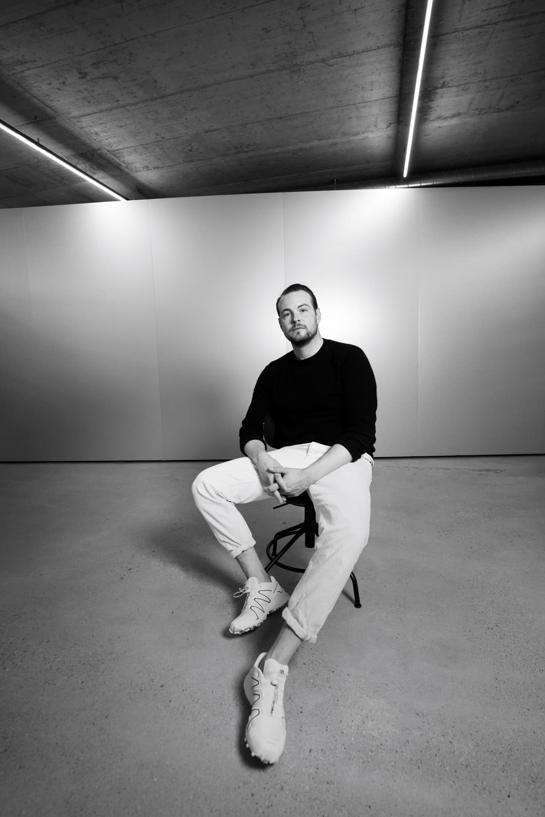 Danilo Maag, CMO et COO d'INUIKII, assis sur une chaise dans un espace épuré aux murs blancs et plafond béton