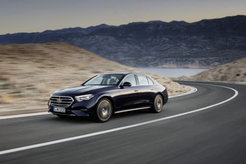 Nouvelle Mercedes-Classe E berline noire roulant sur une route sinueuse en montagne désertique