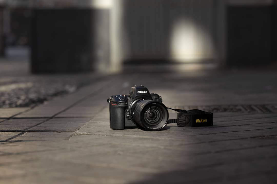 Appareil photo hybride Nikon Z 8 noir posé sur un sol en bois avec sa dragonne