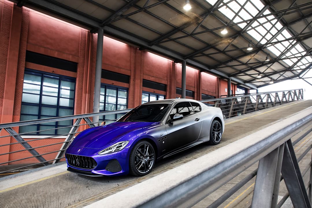 Maserati GranTurismo Zéda bleu et blanc présentée dans un garage moderne aux murs de brique rouge