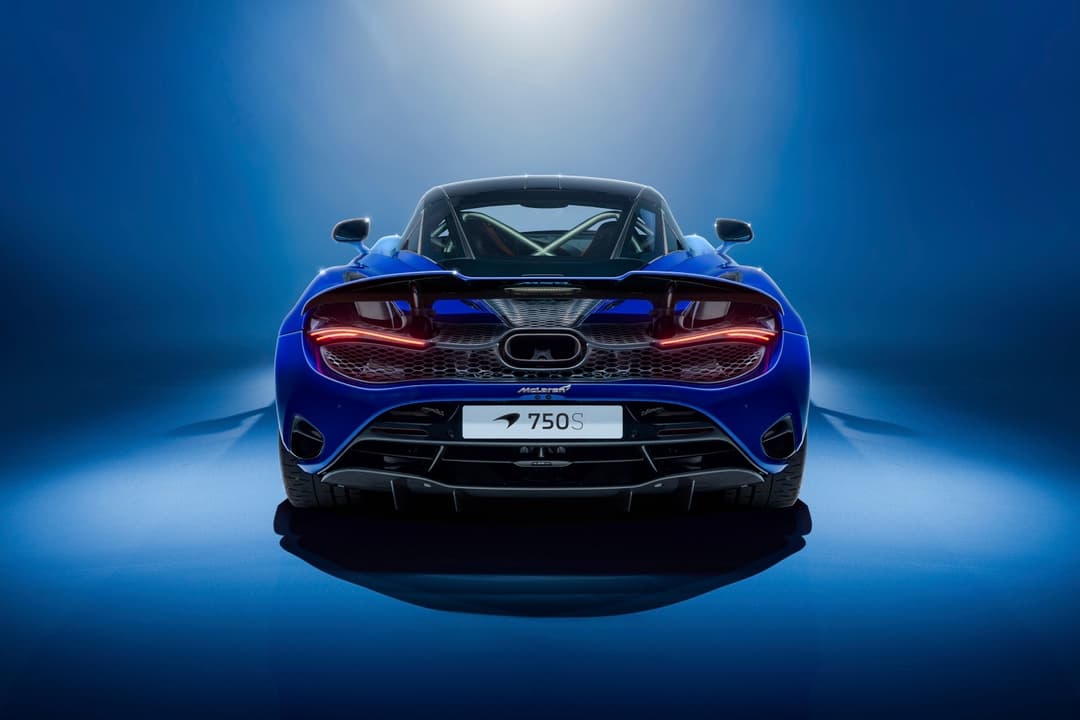 McLaren 750S Spectrum Theme bleue vue de face sur fond bleu, phares et grille métallisés, aileron arrière actif