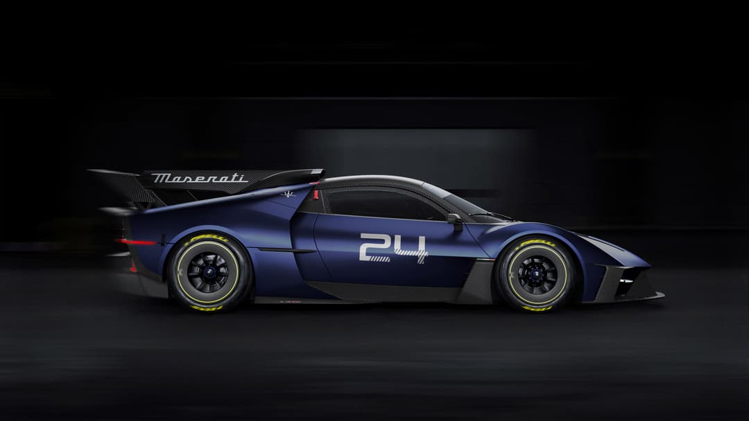 Maserati MCXtrema bleu foncé de profil, voiture de piste avec aileron aérodynamique, pneus à flancs jaunes, sur fond noir