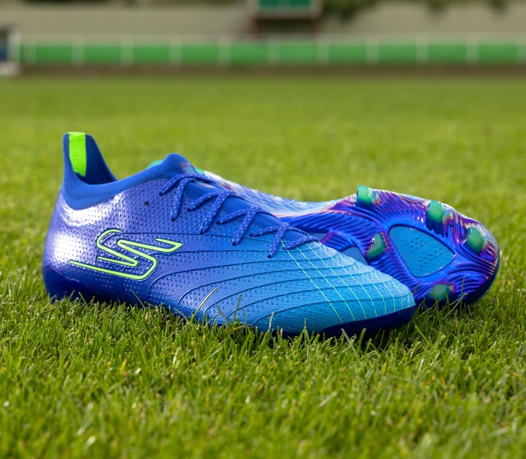 Chaussure de football Skechers bleue et vert fluo posée sur un terrain de gazon