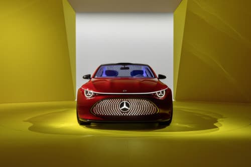 Mercedes-Benz Concept CLA rouge vue de face, avec calandre illuminée, dans un environnement jaune épuré