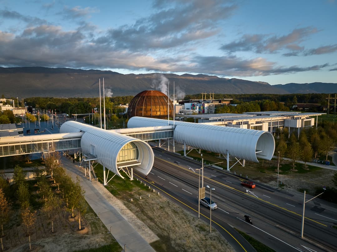 Le Portail de la science du CERN avec ses structures cylindriques blanc et dome cuivré, situé dans le campus genevois face aux montagnes