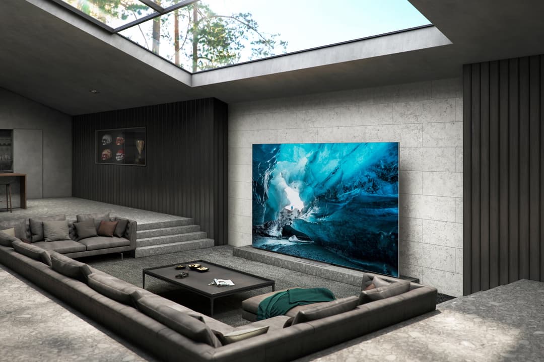 Micro LED TV Samsung affichant une grotte de glace bleue, intégrée dans un salon design aux murs gris clair et mobilier épuré