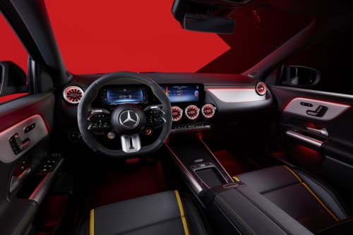 Habitacle du Mercedes-AMG GLA avec volant et système MBUX aux écrans modernes, teintes rouge et noir