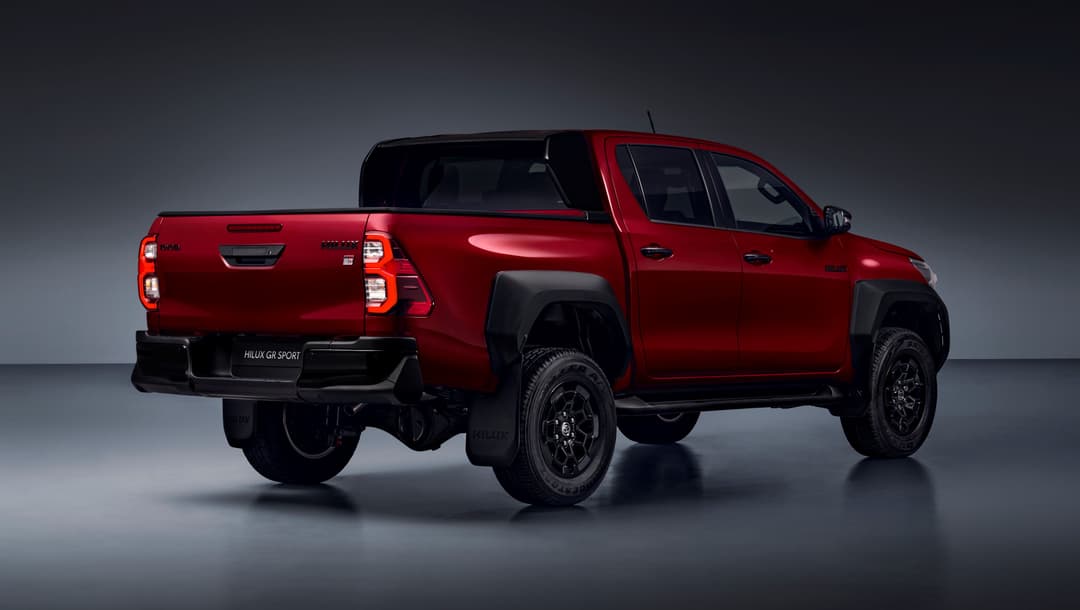 Toyota Hilux GR SPORT II rouge avec calandre noire, marchepied latéral noir, rétroviseurs noirs et bas de caisse argenté
