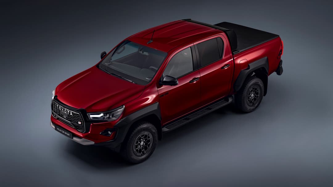 Toyota Hilux GR SPORT II rouge avec plateau découvert, vue trois quarts sur fond gris