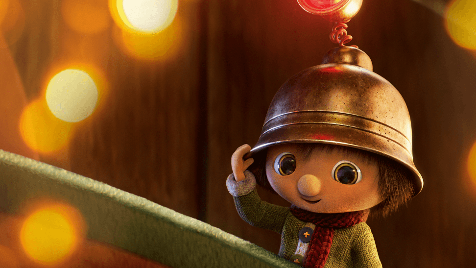 Le lutin Finn porte un bonnet doré et un pull vert, entouré de lumières de Noël dorées en arrière-plan