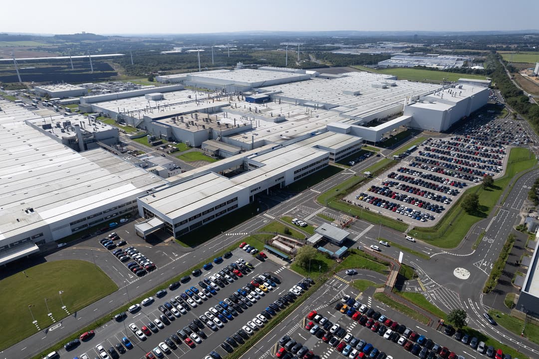 Usine Nissan de Sunderland vue aérienne, avec ses bâtiments blancs, parkings de voitures et paysage verdoyant