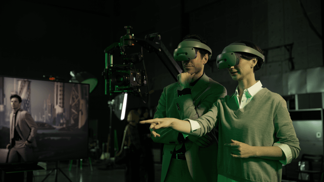 Deux créateurs portant des casques de réalité virtuelle collaborent sur un plateau de production 3D avec caméra professionnelle