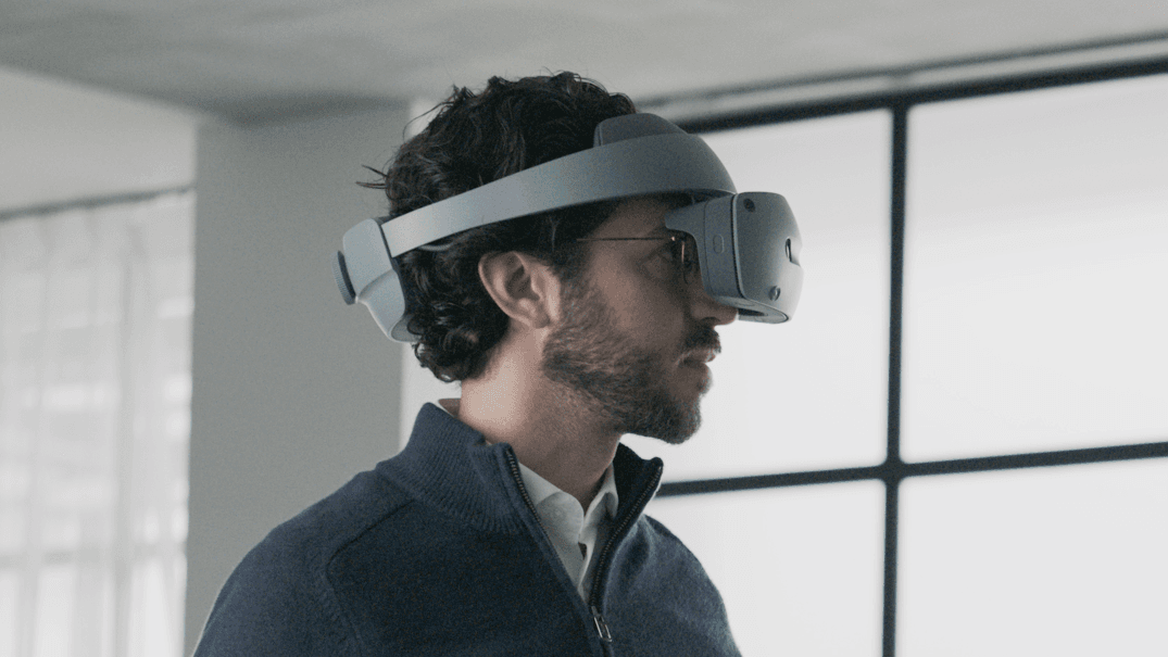 Homme portant un casque Sony blanc de réalité virtuelle et spatiale, relevé légèrement sur son front