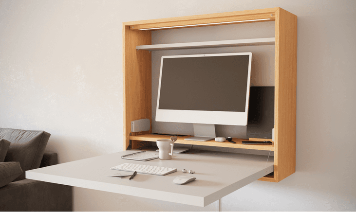 Bureau rabattable en bois clair avec plateau blanc intégré, écran informatique et accessoires de travail organisés, rabat fermé vers le haut
