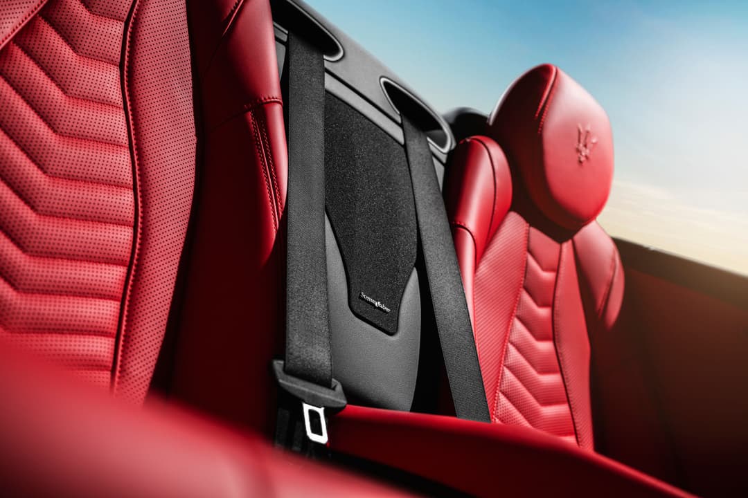 Détail de l'intérieur de la Maserati GranCabrio avec sièges en cuir rouge et appuie-têtes Trident sous ciel dégagé