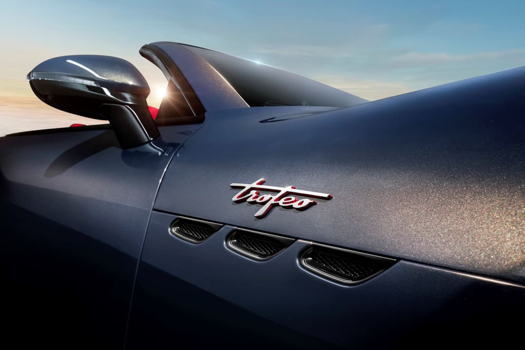 Maserati GranCabrio décapotable grise, vue latérale détaillant le logo Trident et les trois aérateurs élégants du capot