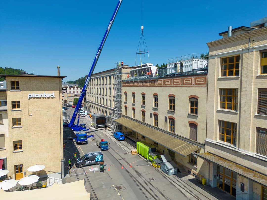 Aérienne du chantier de construction du nouveau site de production Planted, avec grue bleue et bâtiments en rénovation en milieu urbain
