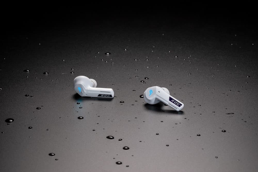 Écouteurs ASUS ROG Cetra True Wireless SpeedNova blancs avec accents bleus, posés sur fond gris avec gouttes d'eau