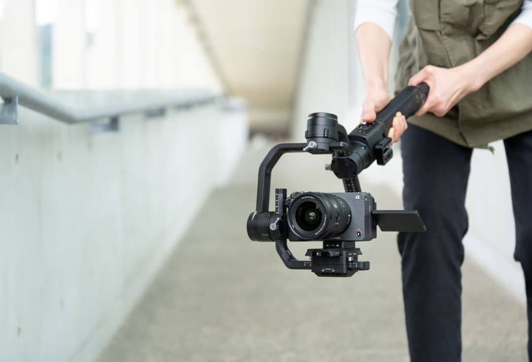 Objectif Sony FE 16-25mm F2.8 G monté sur caméra, tenu en main avec stabilisateur gimbal